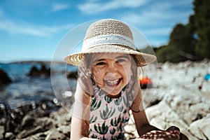 Adorable happy girl wearing straw hat.