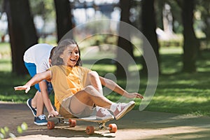 adorable happy kids having fun with longboard