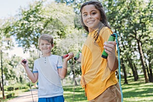 adorable happy kids hiking skipping ropes and smiling at camera