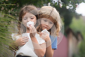 Adorable happy kids outdoors on summer day, little boy kissing a girl. Lovely little boy and girl, have fun and hugging