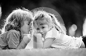 Adorable happy kids outdoors on summer day, little boy kissing a girl. Lovely little boy and girl, have fun outdoor
