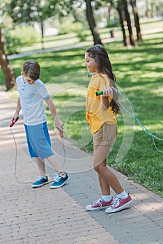 adorable happy kids playing with jumping ropes