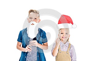 adorable happy kids with santa hat and fake beard smiling at camera