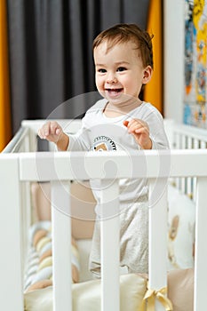 Adorable happy lifestyle child. Small boy playing in the crib.