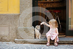 Adorabile felice bambina e un gatto all'aperto.