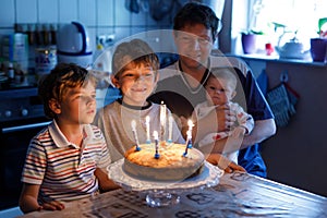 Little kid boy and family, father, brother and baby sister celebrating birthday