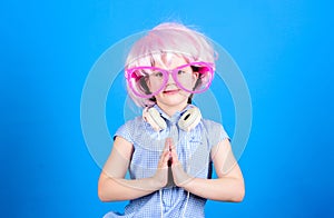 Adorable headset user with praying hands. Small child wearing adjustable white headset and pink hair wig. Little girl