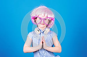 Adorable headset user with praying hands. Small child wearing adjustable white headset and pink hair wig. Little girl