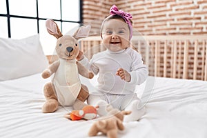 Adorable hispanic baby smiling confident sitting on bed at bedroom