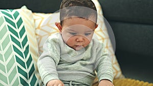 Adorable hispanic baby smiling confident sitting on floor at home