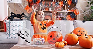 Adorable hispanic girl having halloween party playing with soap bubbles at home