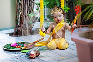 adorable infant dressed as hindu god krishna cute facial expression with flute at janmashtami