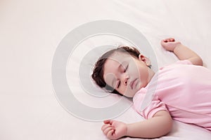 Adorable innocent baby girl sleeping on bed with good dream. Cute mixed race infant baby feel comfortable and taking a rest,