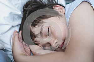 Adorable kid deep sleep in bed in the morning, Child  sleeping on bed. Little boy taking a peaceful nap, Children health care