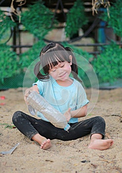 Adorable kid girl playing in garden with soil