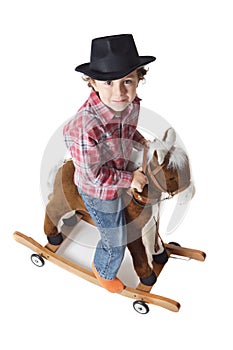 Adorable kid riding a toy horse