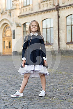 Adorable kid wear elegant school dress with formal look in schoolyard, uniform