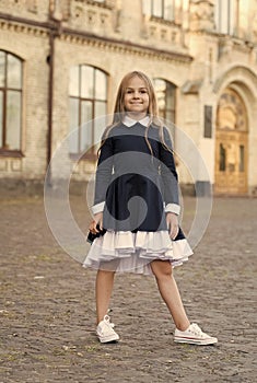 Adorable kid wear elegant school dress with formal look in schoolyard, uniform