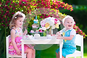 Adorable kids having fun at garden tea party