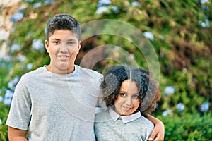 Adorable latin brother and sister hugging at the park