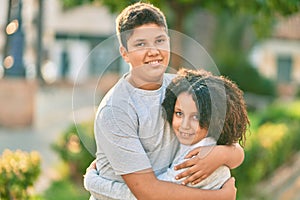 Adorable latin brother and sister hugging at the park