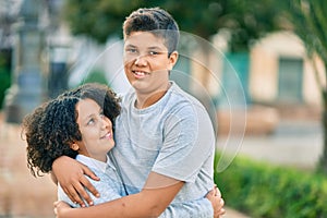 Adorable latin brother and sister hugging at the park