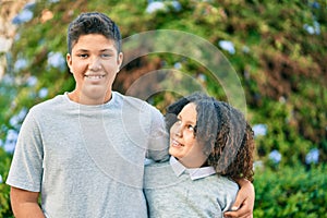 Adorable latin brother and sister hugging at the park