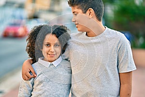 Adorable latin brother and sister hugging at the park