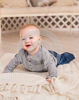 Adorable laughing baby boy in white sunny bedroom. Newborn child relaxing. Family morning at home.