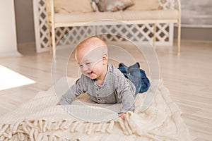 Adorable laughing baby boy in white sunny bedroom. Newborn child relaxing. Family morning at home.