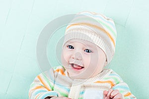 Adorable laughing baby wearing a warm knitted jack