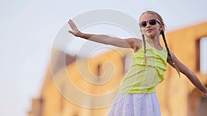 Adorable little active girl having fun in front of Colosseum in Rome, Italy.