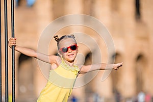 Adorable little active girl having fun in front of Colosseum in Rome, Italy. Kid spending childhood in Europe
