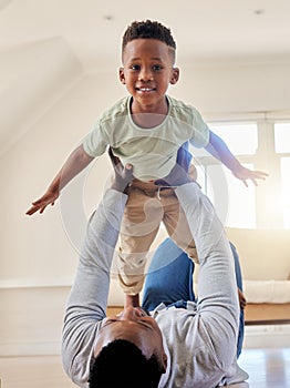 Adorable little african american boy playing in the living room at home with his father. Cute male child smiling and