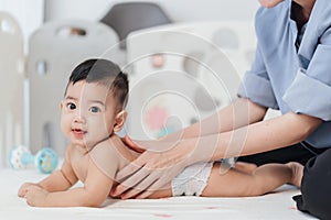 Adorable little Asian baby back massage for stimulate development by mother. Mother makes massage for happy baby. Infant