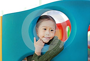 Adorable little Asian child girl playing toy playhouse at indoor playground