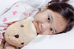 Adorable little Asian girl sleep with bear doll