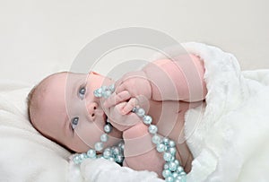 Adorable little baby with beads looking aside