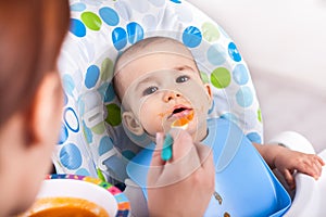 Adorable little baby boy enjoy eating fruit mash