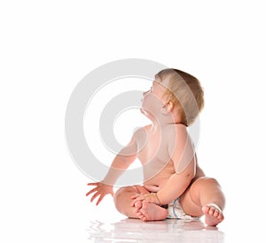 Adorable little baby boy in white diapers looking up on white background.