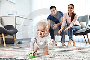 Adorable little baby crawling near parents