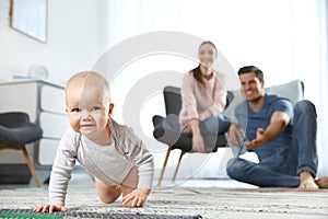 Adorable little baby crawling near parents