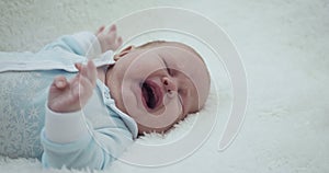 Adorable little baby girl crying lying on her back.