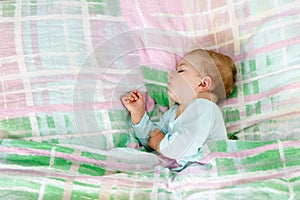 Adorable little baby girl sleeping in bed. Calm peaceful child dreaming during day sleep