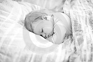 Adorable little baby girl sleeping in bed. Calm peaceful child dreaming during day sleep. Beautiful baby in parents bed