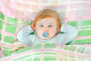 Adorable little baby girl sleeping in bed. Calm peaceful child dreaming during day sleep. Beautiful baby in parents bed