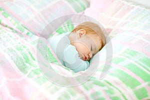 Adorable little baby girl sleeping in bed. Calm peaceful child dreaming during day sleep. Beautiful baby in parents bed