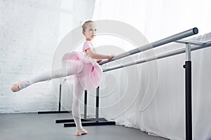 adorable little ballerina in pink tutu practicing in ballet