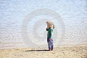 Adorable little blond kid boy at ocean beach