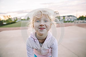 Adorable little blonde Caucasian girl child making funny silly face